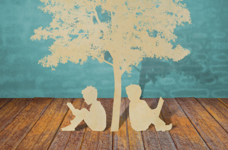 Paper cut of children read a book under tree on old book